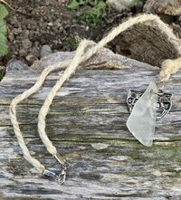 River Glass Necklace    river glass  w comedy & tragedy charm on  22 in Hemp cord 