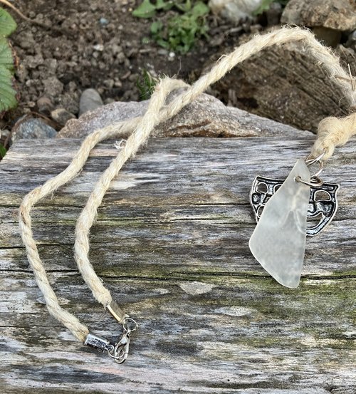River Glass Necklace    river glass  w comedy & tragedy charm on  22 in Hemp cord 
