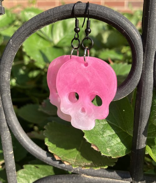 Resin pink toned skull earrings